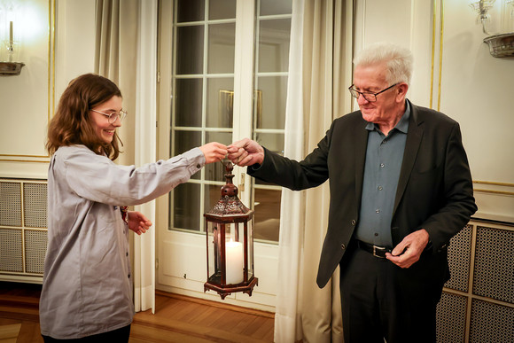 Aktion Kretschmann nimmt Friedenslicht entgegen Eine Pfadfinderin (links) übergibt Ministerpräsident Winfried Kretschmann (rechts) das Friedenslicht.