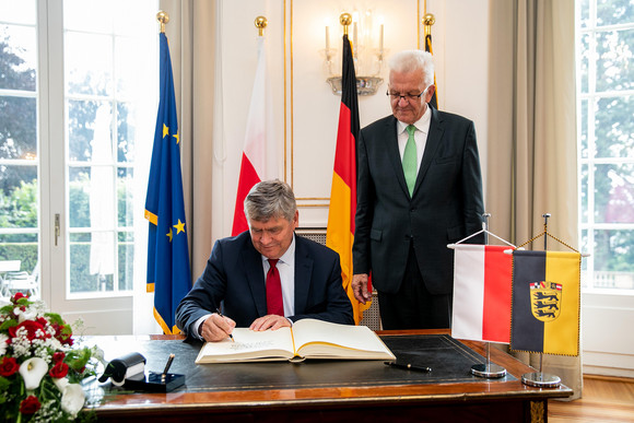 Europa Weitere Kooperationen mit Woiwodschaft Łódźkie Woiwodschaftsmarschall Witold Stępień (l.) beim Eintrag in das Gästebuch der Landesregierung, daneben steht Ministerpräsident Winfried Kretschmann (r.)