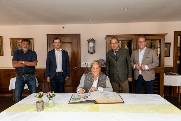 Beim Besuch der Schlossanlage der Rüdt von Collenberg in Buchen-Bödigheim trägt sich Ministerin Nicole Razavi MdL (sitzend) in das goldene Buch der Stadt ein. Stehend von links: Prof. Dr. Claus Wolf (Präsident Landesamt für Denkmalpflege), Dr. Björn-Christian Kleih (Erster Landesbeamter Neckar-Odenwald-Kreis), Roland Burger (Bürgermeister Buchen), Mario Nitschmann (Ministerium für Landesentwicklung und Wohnen)