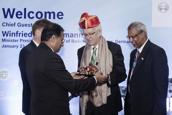 Delegationsreise Ministerpräsident Kretschmann besucht Indien Ministerpräsident Winfried Kretschmann (M.) erhält bei Bosch India in Pune zur Begrüßung die traditionelle Kopfbedeckung „Pagarhi“ und ein Gastgeschenk.
