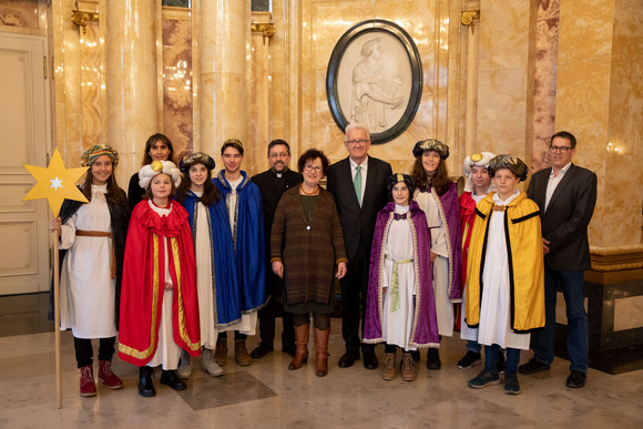 Aktion Dreikönigssingen Kretschmann empfängt Sternsingergruppen Ministerpräsident Winfried Kretschmann und seine Frau Gerlinde (M.) mit den Sternsingern der Kirchengemeinde St. Anastasia (Baisingen) (Bild: Staatsministerium Baden-Württemberg)