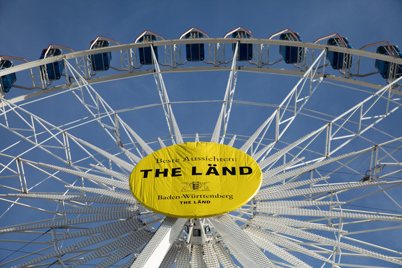 Imagekampagne Baden-Württemberg ist „THE LÄND“ Riesenrad auf dem Stuttgarter Schlossplatz mit der Aufschrift „Beste Aussichten: THE LÄND“ und dem Landeswappen