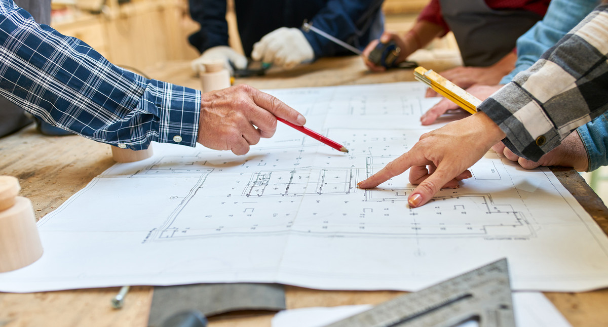 Architekten und Handwerker besprechen Bauplan