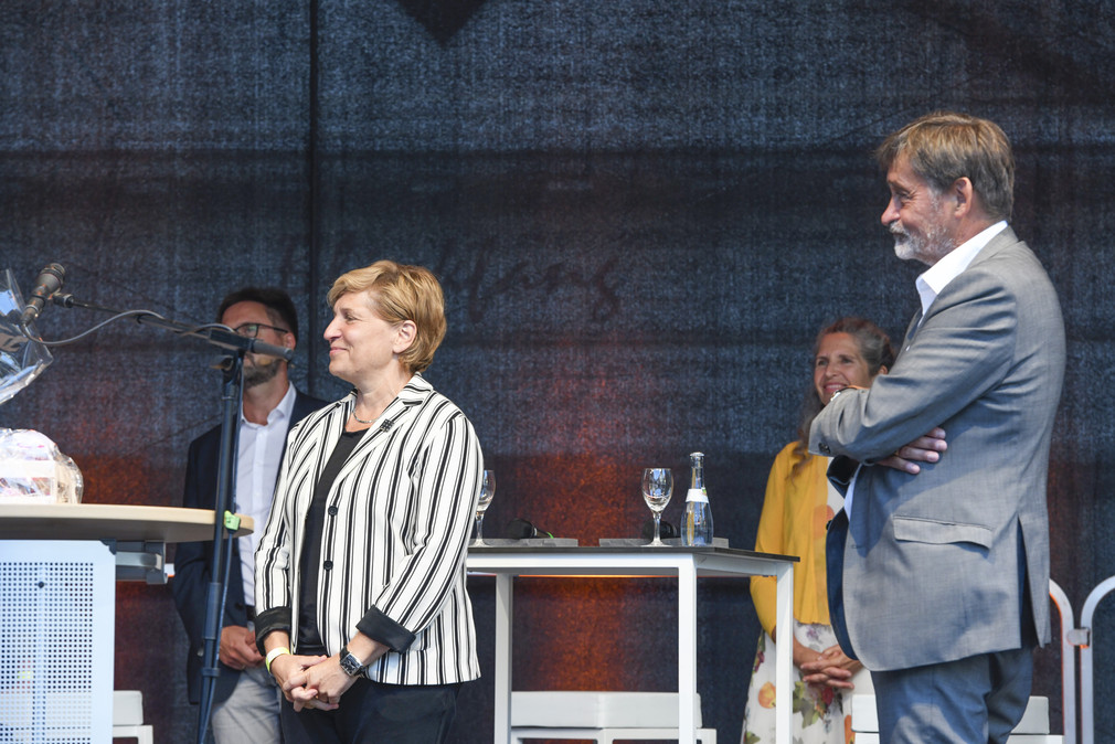 Ministerin Nicole Razavi MdL steht auf der Veranstaltungsbühne und neben ihr steht Herr Prof. Wolf, Präsident des Landesamtes für Denkmalpfelge Baden-Württemberg