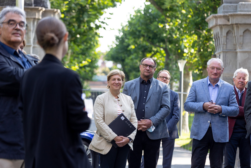 Ministerin Nicole Razavi MdL (links) steht vor dem Schloss Montfort in Langenargen neben den Landtagsabgeordneten Klaus Hoher MdL, FDP/DVP (Mitte) und August Schuler MdL, CDU (rechts) und weiteren Teilnehmerinnen und Teilnehmern der Reise