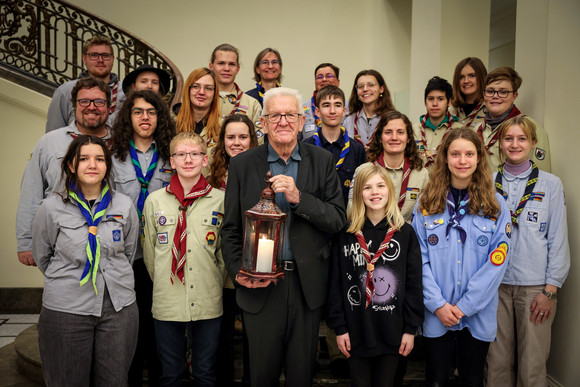 Aktion Kretschmann nimmt Friedenslicht entgegen Gruppenbild mit Ministerpräsident Winfried Kretschmann (vorne in der Mitte) mit dem Friedenslicht in den Händen und jugendlichen Pfadfinderinnen und Pfadfindern
