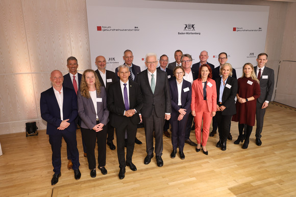 Gruppenbild mit Ministerpräsident Winfried Kretschmann, Wirtschaftsstaatssekretär Dr. Patrick Rapp (Fünfter von links), Staatsminister und Chef der Staatskanzlei Jörg Krauss (Neunter von links), Dr. Claudia Luther, Geschäftsführerin der BIOPRO Baden-Württemberg GmbH (Zehnte von links) und Gesundheitsminister Manne Lucha (Elfter von links).