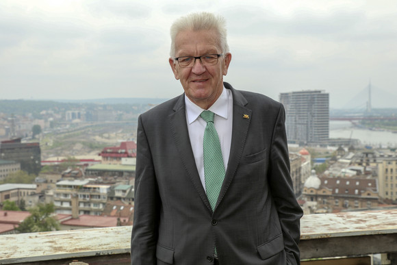 Delegationsreise Kretschmann besucht Südosteuropa Ministerpräsident Winfried Kretschmann steht am 17. April 2018 im Rahmen einer Besichtigung eines Architekturprojekts in einem ehemaligen Bankgebäude vor dem Stadtbild von Belgrad