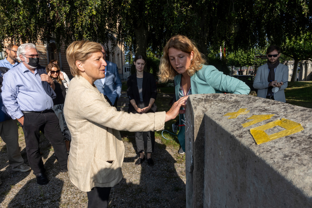 Ministerin Nicole Razavi MdL (links) begutachtet eine Mauer des Schlosss Montfort in Langenargen