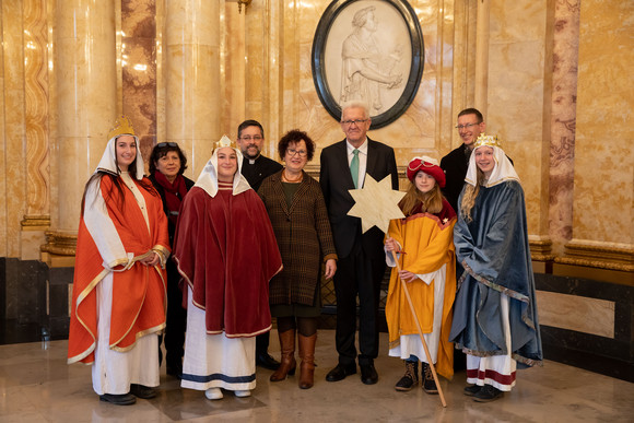 Aktion Dreikönigssingen Kretschmann empfängt Sternsingergruppen Ministerpräsident Winfried Kretschmann und seine Frau Gerlinde (M.) mit den Sternsingern der Kirchengemeinde St. Michael (Honau) (Bild: Staatsministerium Baden-Württemberg)