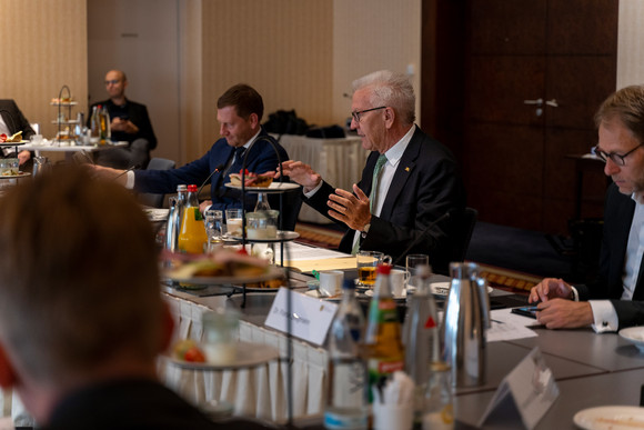 Reise Kretschmann besucht Sachsen Ministerpräsident Winfried Kretschmann (2.v.r.), der sächsische Ministerpräsident Michael Kretschmer (3.v.r.) und Staatssekretär Dr. Florian Stegmann (r.) beim Wissenschaftsfrühstück mit Rektoren und Studierenden (Bild: Staatsministerium Baden-Württemberg)