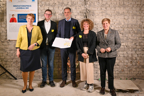 Staatssekretärin Andrea Lindlohr MdL (l.) und Ministerin Nicole Razavi MdL (r.) überreichen den Lehmbaupreis in der Kategorie Industriebau für den Weleda Cradle-Campus