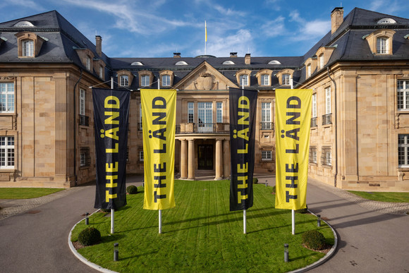 Imagekampagne Baden-Württemberg ist „THE LÄND“ Vier Fahnen mit der Aufschrift „THE LÄND“ vor der Villa Reitzenstein in Stuttgart