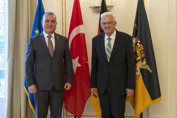 Antrittsbesuch Kretschmann empfängt türkischen Botschafter Ministerpräsident Winfried Kretschmann (rechts) und der türkische Botschafter Ahmet Başar Şen (links) stehen in der Villa Reitzenstein vor Fahnen.