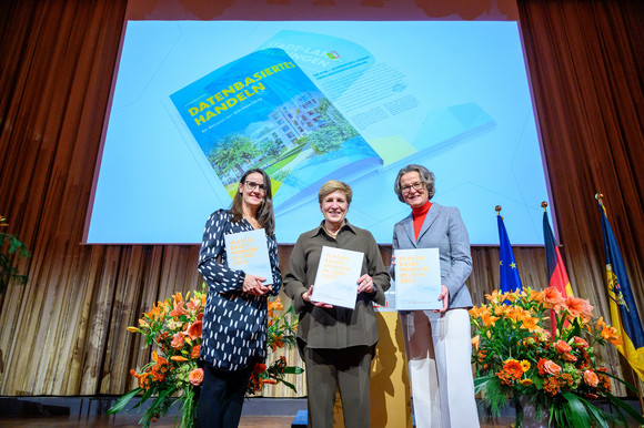 v.l.: Karen Pein, Senatorin der Behörde für Stadtentwicklung und Wohnen der Freien und Hansestadt Hamburg, Nicole Razavi, Ministerin für Landesentwicklung und Wohnen des Landes Baden-Württemberg, und Ina Scharrenbach, Ministerin für Heimat, Kommunales, Bau und Digitalisierung des Landes Nordrhein-Westfalen, stellen die Festschrift „Planen, Bauen, Wohnen im Jahr 2050“ zum Jubiläum 75 Jahre Bauministerkonferenz vor