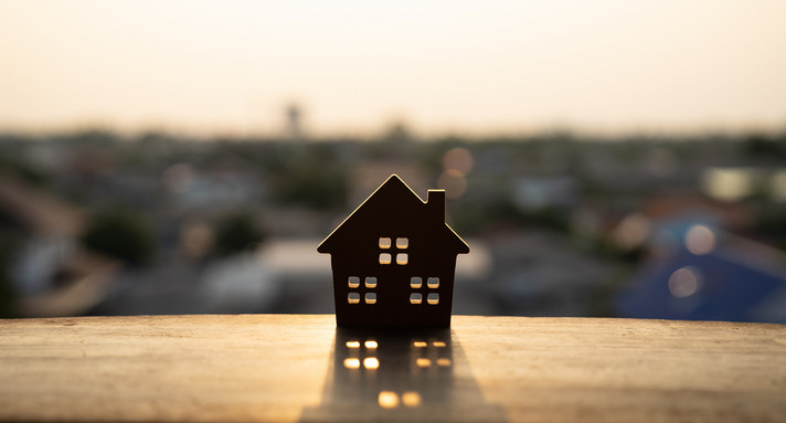 Miniaturholzhaus auf einem Holztisch am Fenster stehend