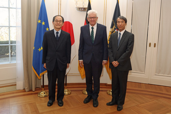 Antrittsbesuch Kretschmann empfängt japanischen Botschafter Der japanische Botschafter Hidenao Yanagi (links), Ministerpräsident Winfried Kretschmann (Mitte) und der japanische Generalkonsul Nobutaka Maekawa (rechts) stehen in der Villa Reitzenstein vor Fahnen.
