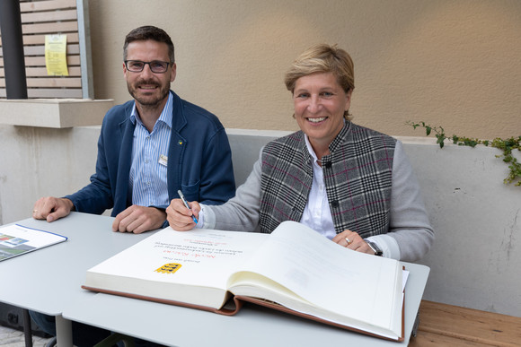 Denkmalreise Ministerin Razavi besucht Tabakscheunen in Rheinstetten Ministerin Nicole Razavi MdL trägt sich ins goldene Buch der Stadt Rheinstetten ein. Links: Sebastian Schrempp (Oberbürgermeister Rheinstetten)