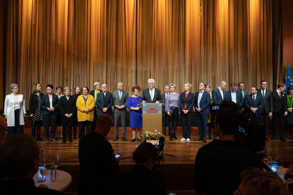 Empfang Neujahrsempfang der Landesregierung Ministerpräsident Winfried Kretschmann (Mitte) steht mit seiner Ehefrau Gerlinde und den Mitgliedern der Landesregierung auf der Bühne und spricht zu den Gästen.