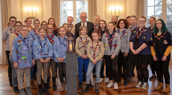 Aktion Pfadfinder übergeben Friedenslicht Ministerpräsident Winfried Kretschmann mit einer Delegation von Pfadfinderinnen und Pfadfindern anlässlich der Übergabe des diesjährigen Friedenslichts (Bild: Staatsministerium Baden-Württemberg)