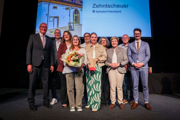 Denkmalpflege Verleihung Innovationspreis „Denkmal – Energie – Zukunft“ Ministerin Nicole Razavi MdL (3. von rechts) überreicht den Innovationspreis für die Sanierung der Zehntscheuer in Karlsdorf-Neuthard an die Bürgerstiftung Karlsdorf-Neuthard.