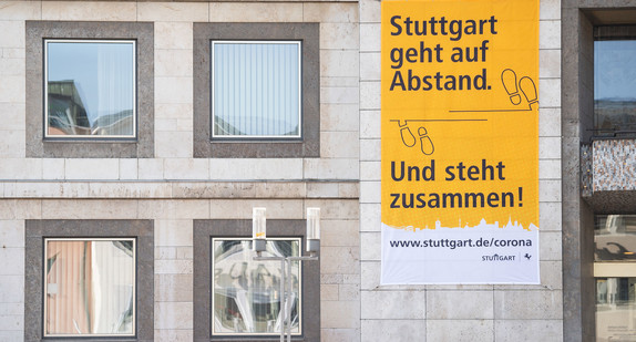 Ein Plakat mit der Aufschrift "Stuttgart geht auf Abstand. Und steht zusammen!" hängt am Rathaus.(Bild: picture alliance/Marijan Murat/dpa)