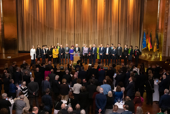 Empfang Neujahrsempfang der Landesregierung Ministerpräsident Winfried Kretschmann (Mitte) steht mit seiner Ehefrau Gerlinde und den Mitgliedern der Landesregierung auf der Bühne und spricht zu den Gästen.