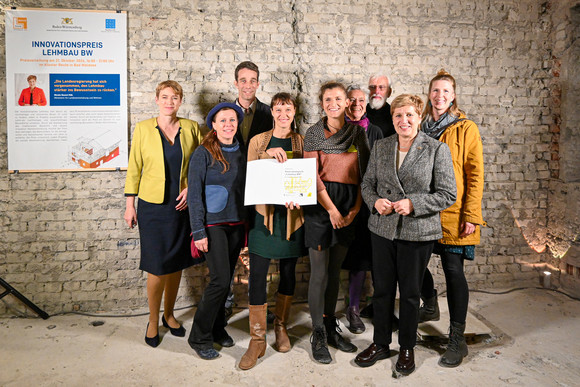 Staatssekretärin Andrea Lindlohr MdL (l.) und Ministerin Nicole Razavi MdL (r.) überreichen den Lehmbaupreis in der Kategorie Wohnungsbau für die Mehrgenerationen-Wohn- und Lebensgemeinschaft Mühlenbächle