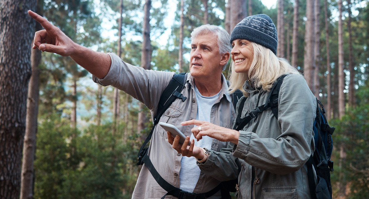 Älteres Paar beim Wandern, mit Smartphone